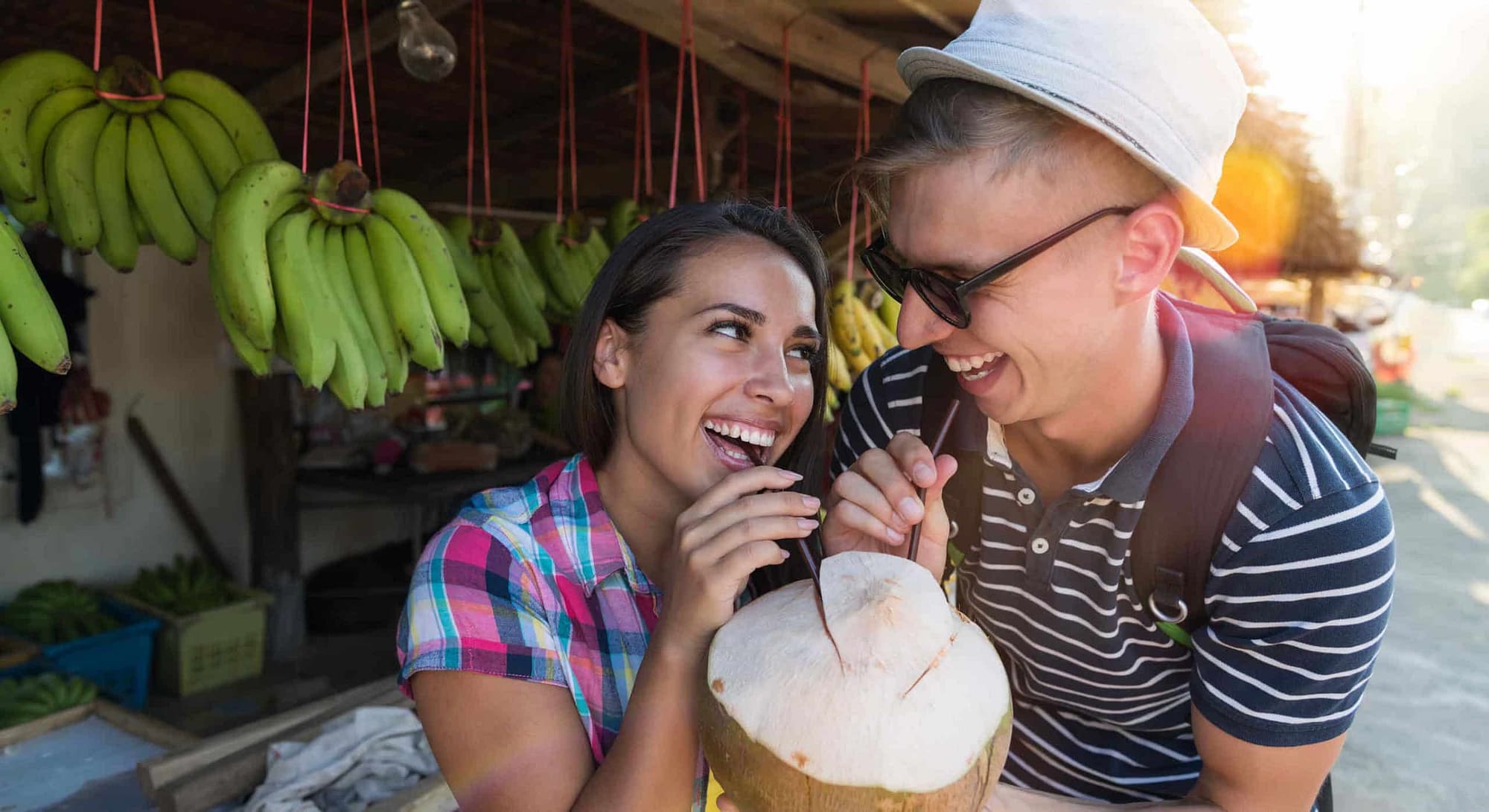 Pärchen trinkt Kokosnuss auf Strassenmarkt in Thailand